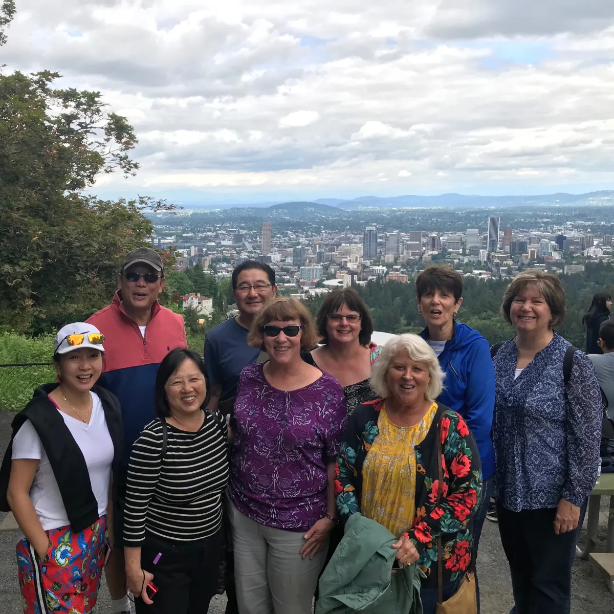 a group of people posing in front of a city skyline view