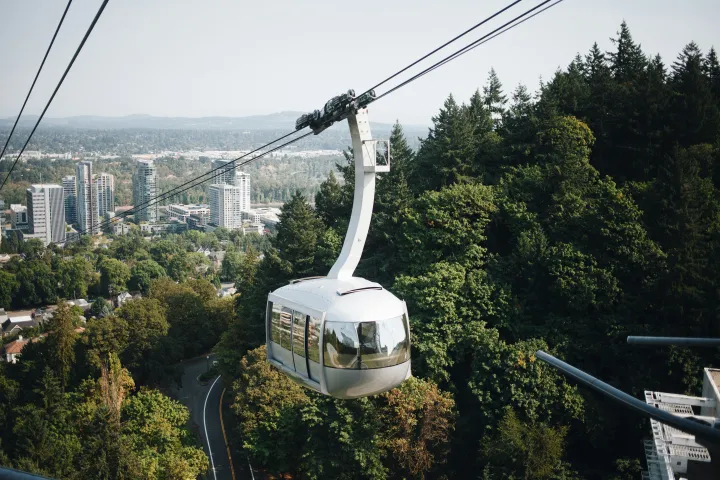 sky tram with trees and city buildings in background